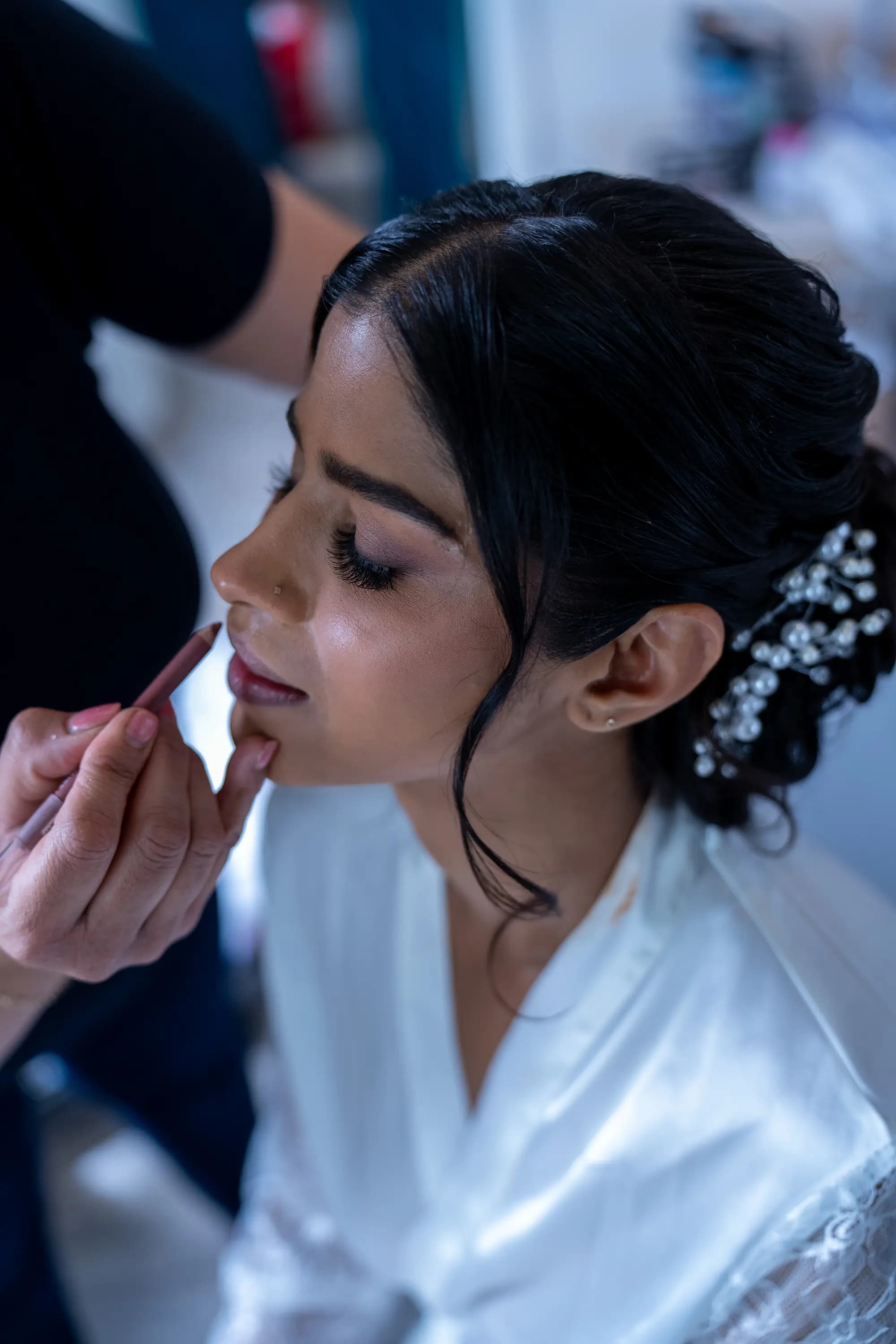 Bride having her makeup finished before the ceremony